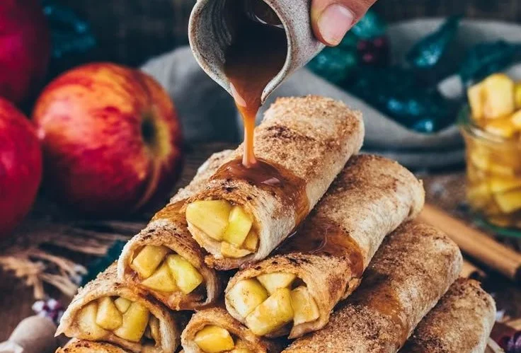 Vegan apple pie toast roll-ups served on a plate with cinnamon and apple slices