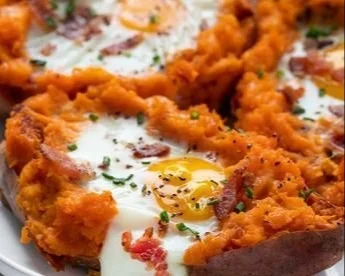 Delicious breakfast sweet potato topped with eggs and herbs
