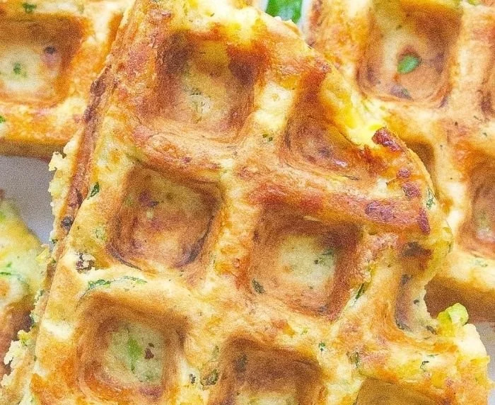 Cheesy cheddar zucchini waffles ready to serve on a plate.