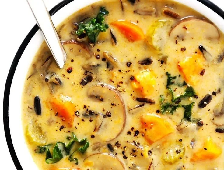 Cozy bowl of autumn wild rice soup filled with veggies and herbs