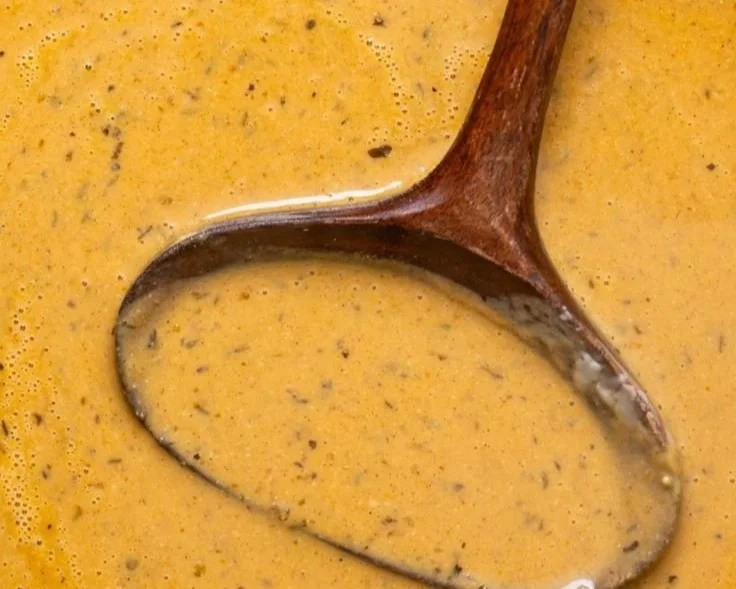 Creamy roasted apple pumpkin soup served in a bowl with fresh herbs