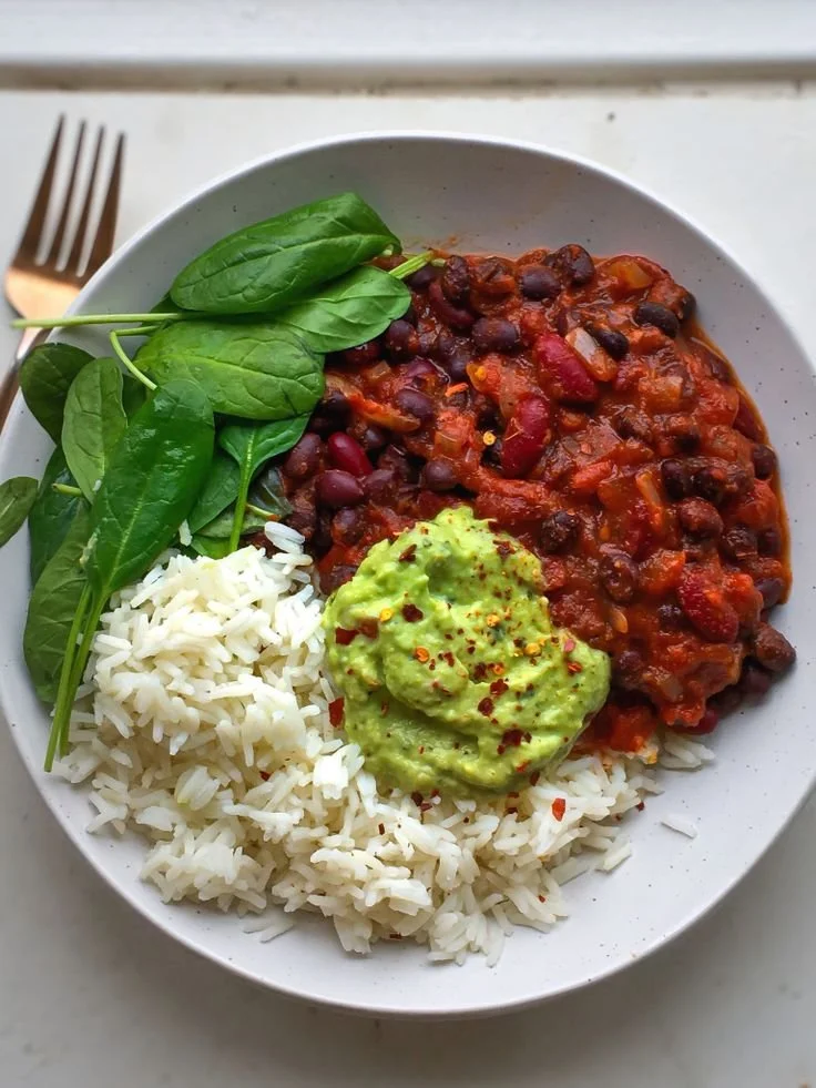 Delicious bowl of easy bean chilli garnished with fresh herbs.