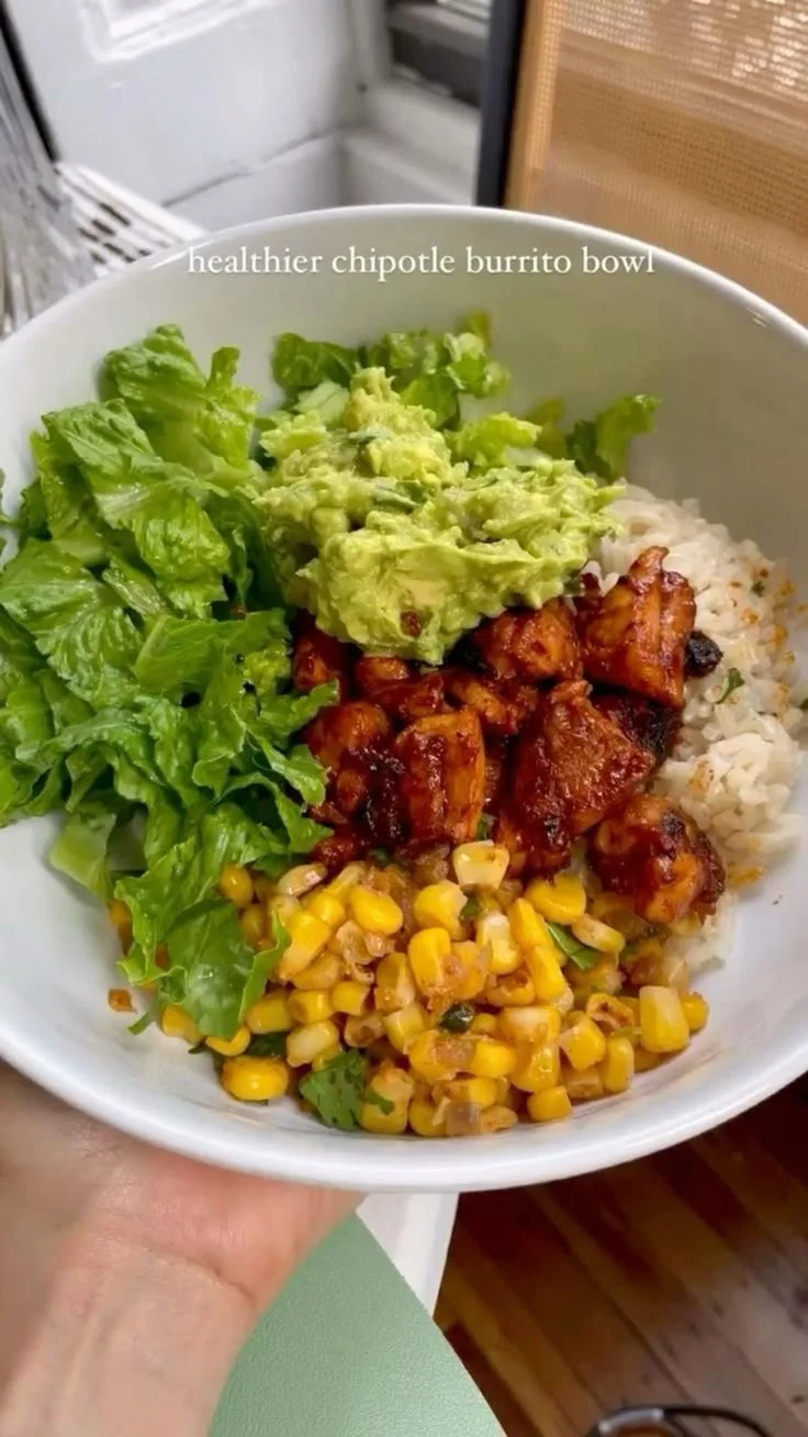 Healthy chipotle bowl with rice, chicken, and fresh toppings