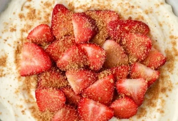 High Protein Strawberry Cheesecake Bowl topped with fresh strawberries and granola.