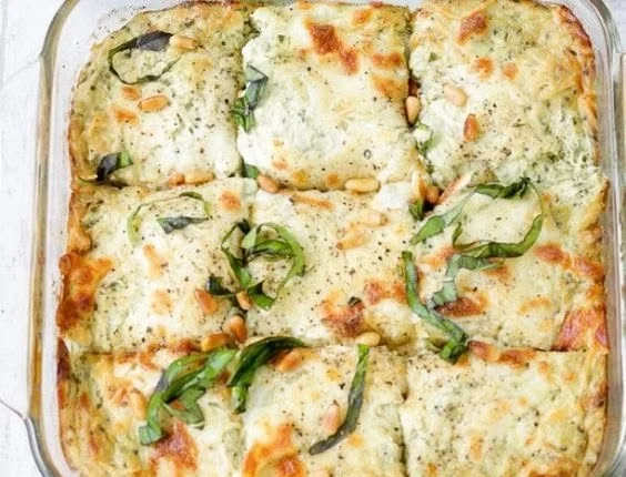 Keto Cheesy Pesto Chicken Casserole topped with melted cheese and fresh pesto