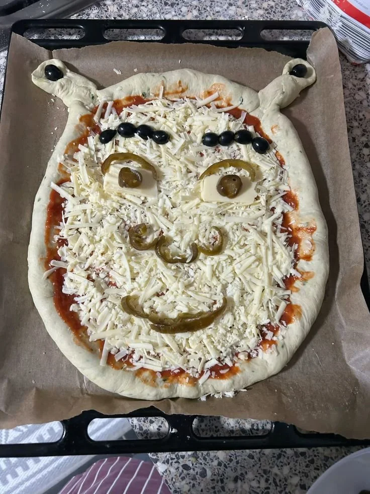Delicious Shrek pizza with green toppings and whimsical design