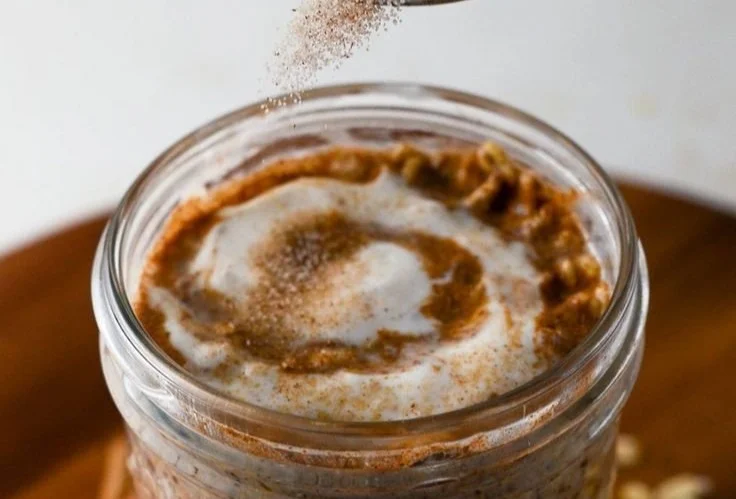 Creamy cinnamon roll overnight oats in a bowl topped with cinnamon and nuts.
