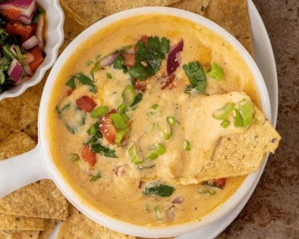 Creamy cottage cheese queso dip served in a bowl with tortilla chips
